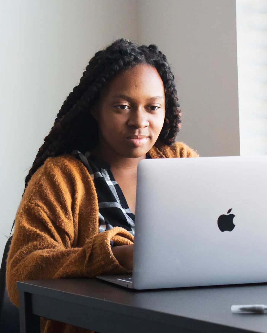 A member working on a laptop at a desk in a bright, quiet corner of a coworking space.
